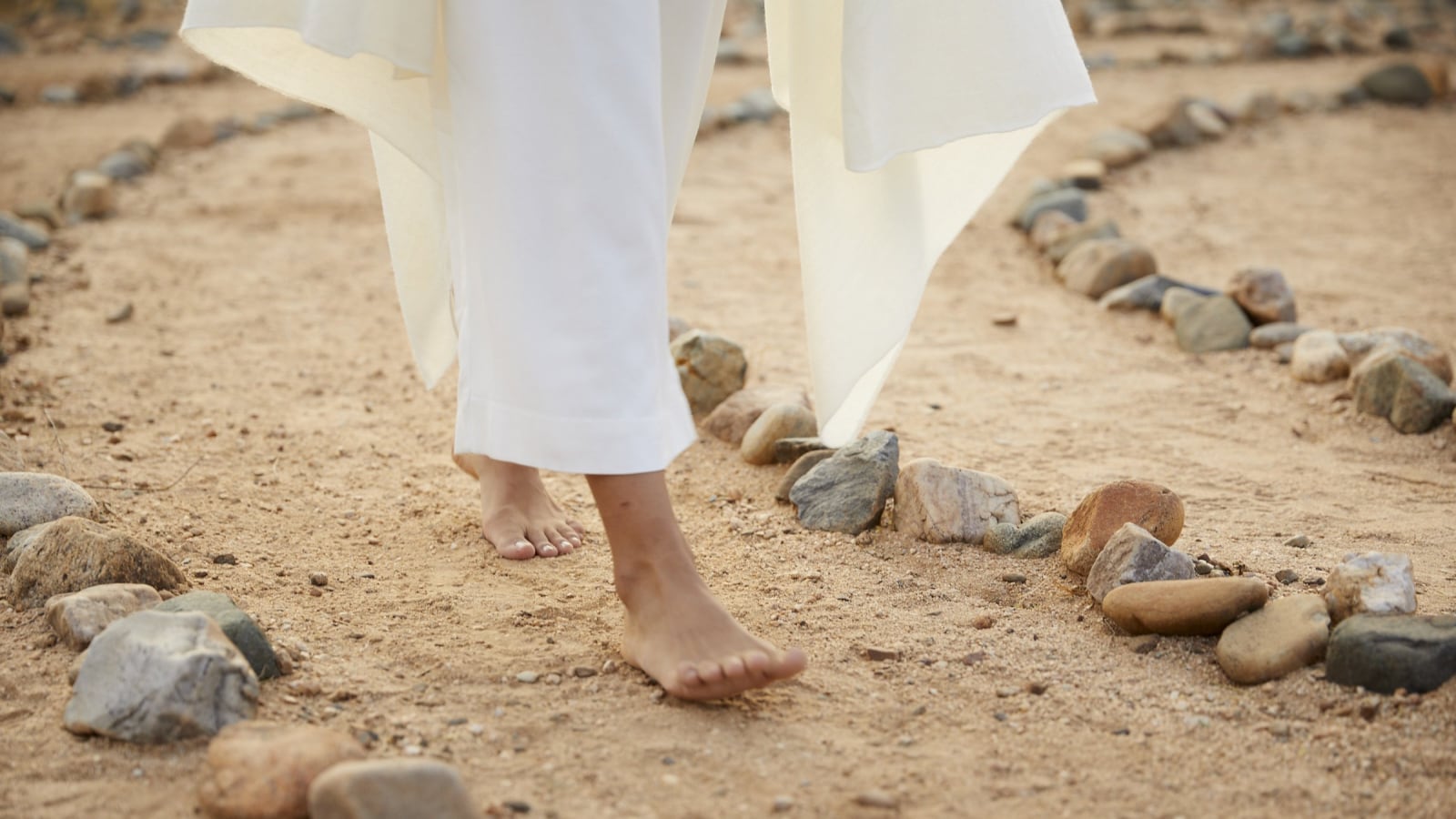 person walking barefoot on a labyrinth walk way