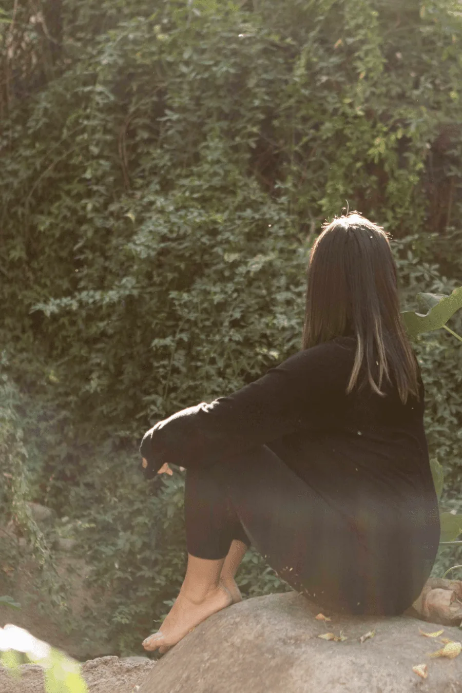 a woman connecting with herself in the wellness retreat surrounded by calm nature