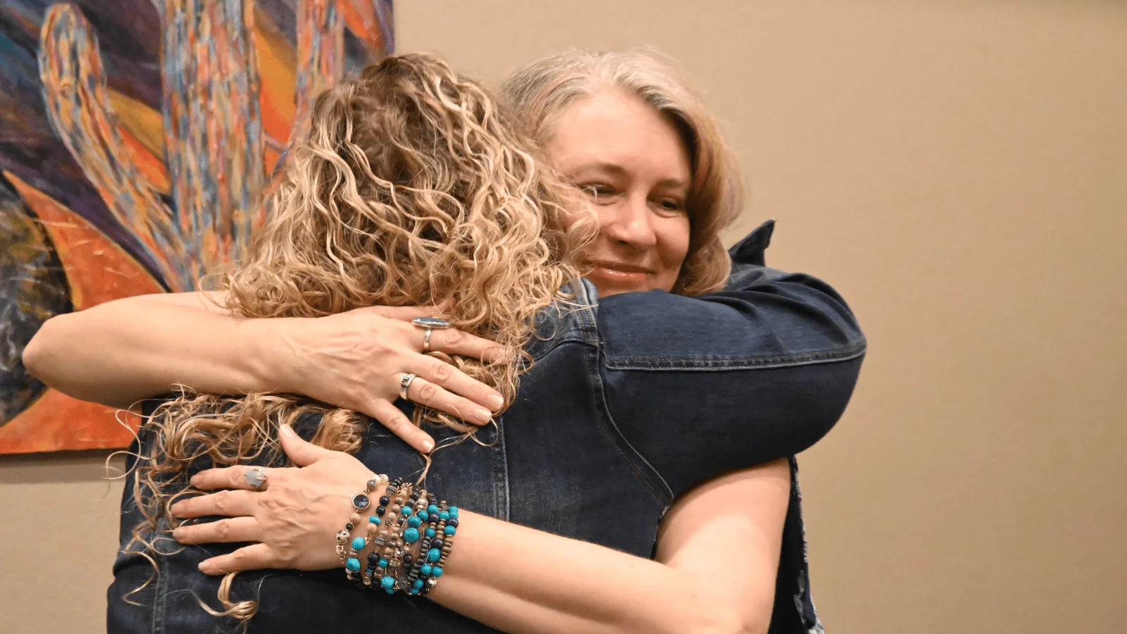 two women embrace warmly, reflecting support and renewal at Miraval's Arizona wellness retreat.