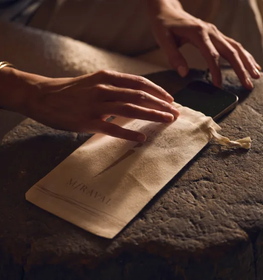 Guest places a smartphone in a Miraval device-free pouch as part of the Miraval Mode experience.