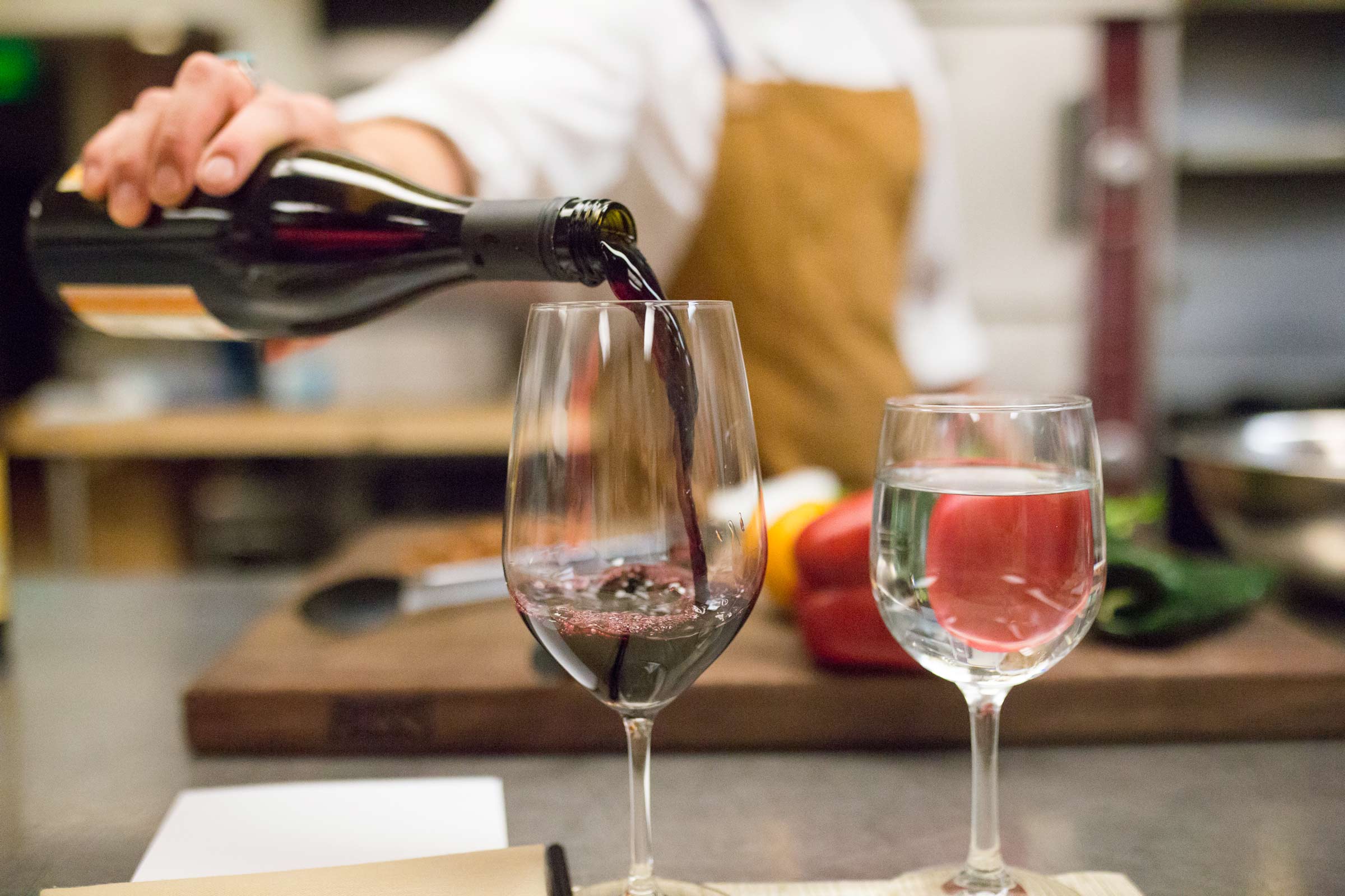 person pouring wine into a glass
