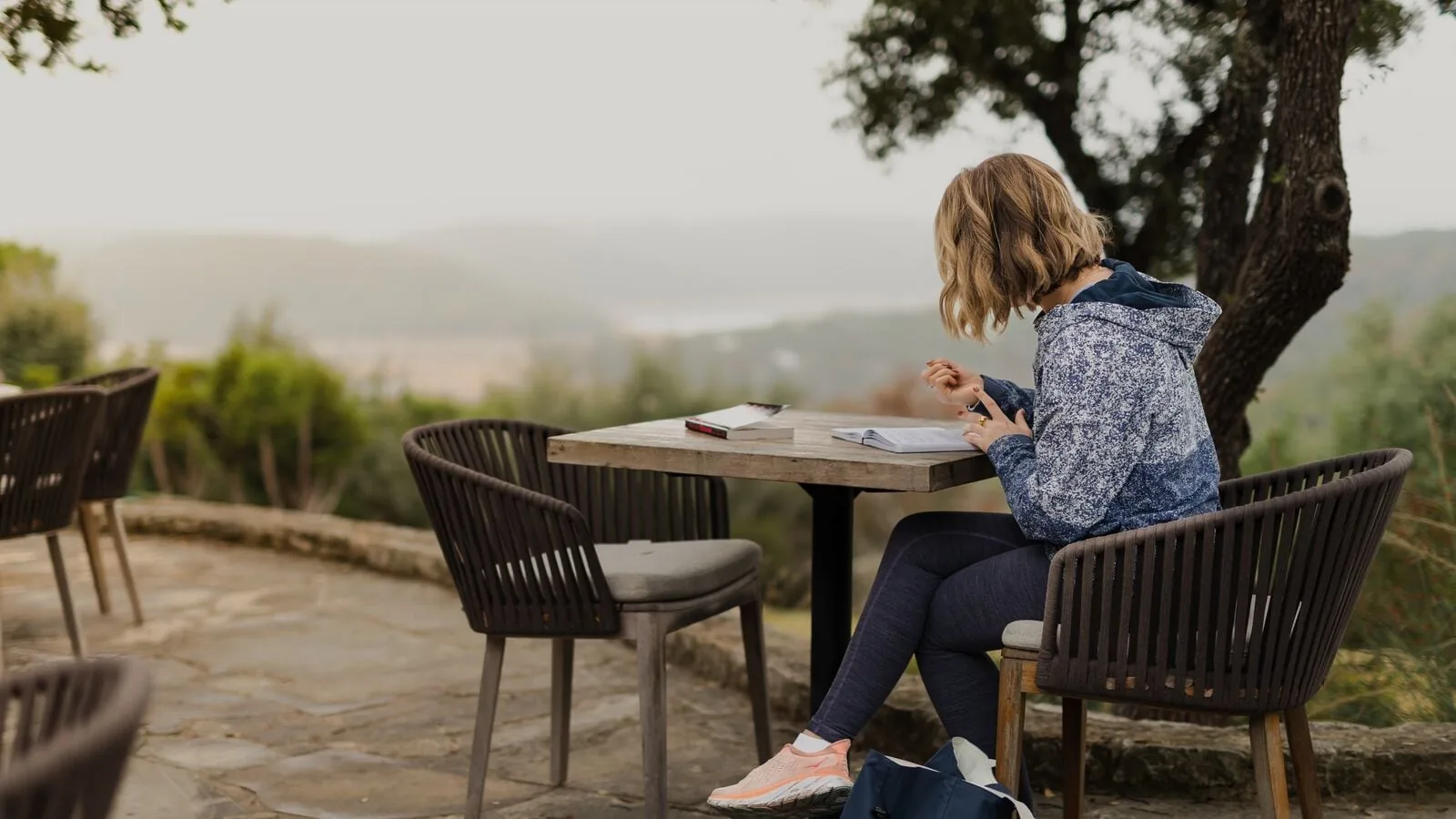 person writing in journal outside