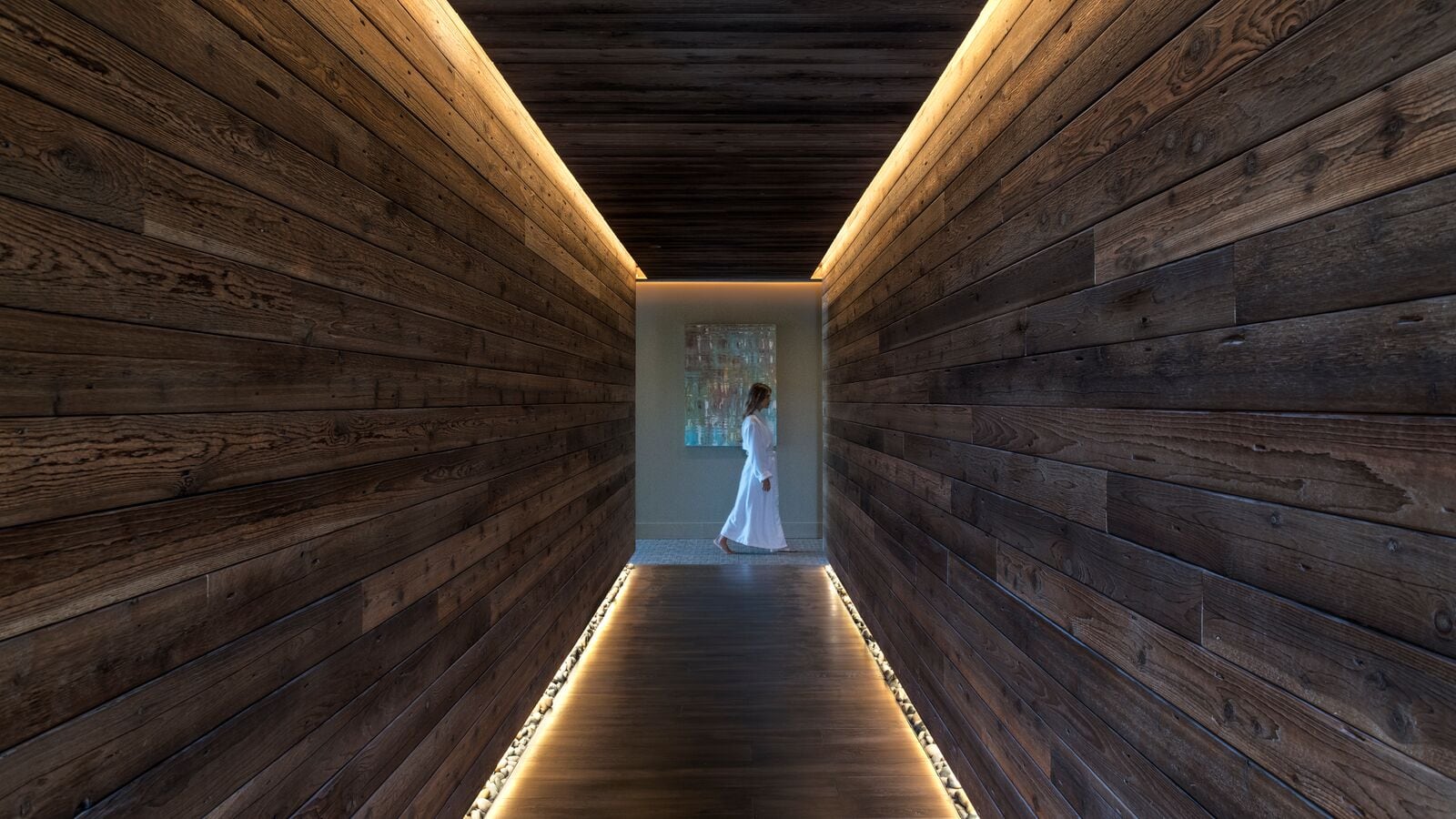 person walking past wooded hall way