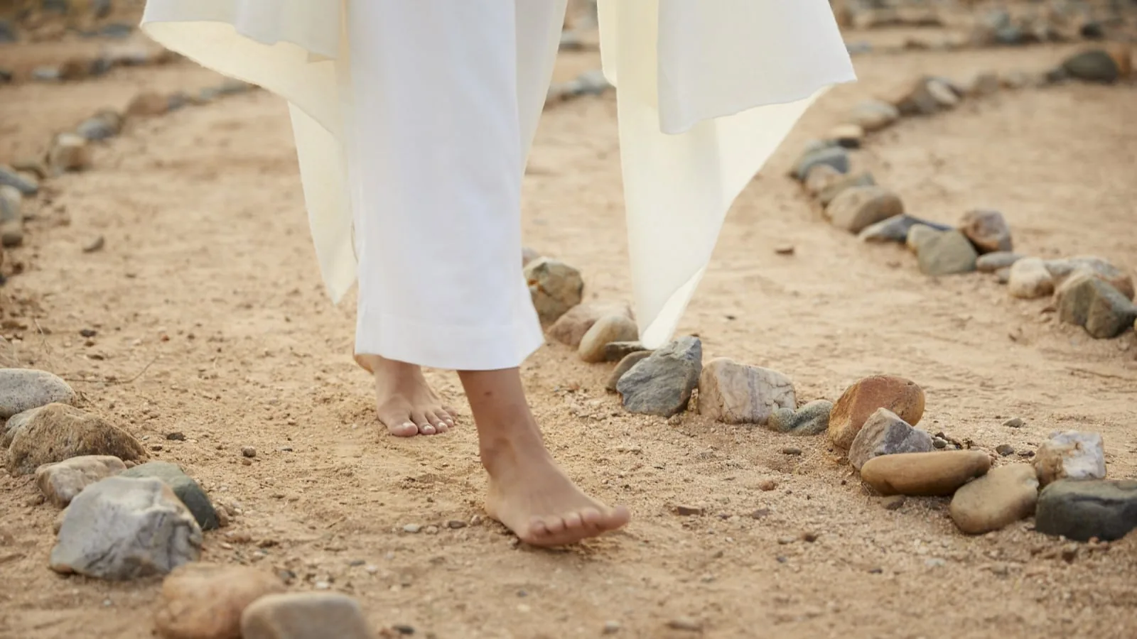 person walking barefoot on a labyrinth walk way