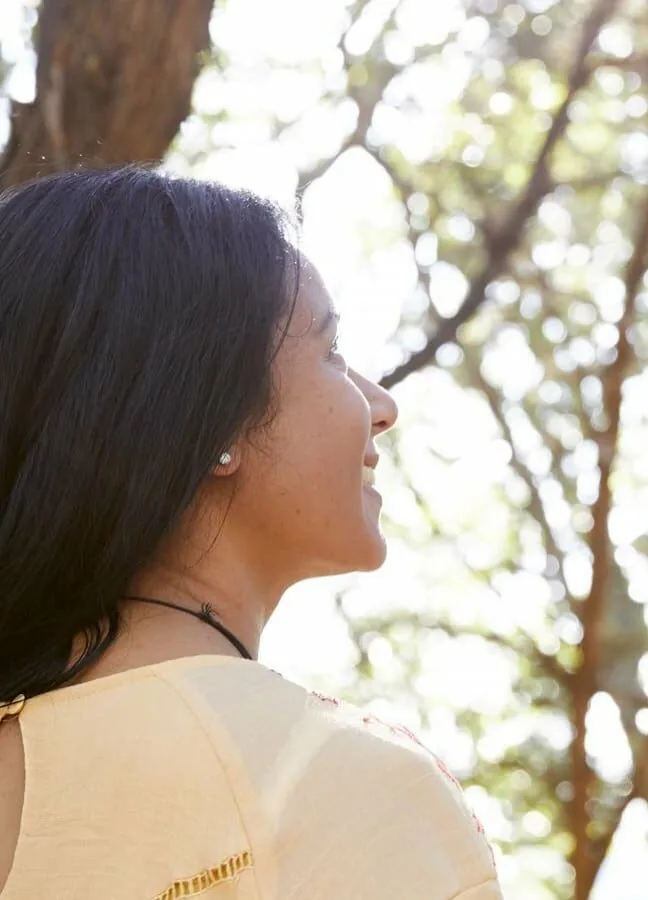 person looking up at the trees