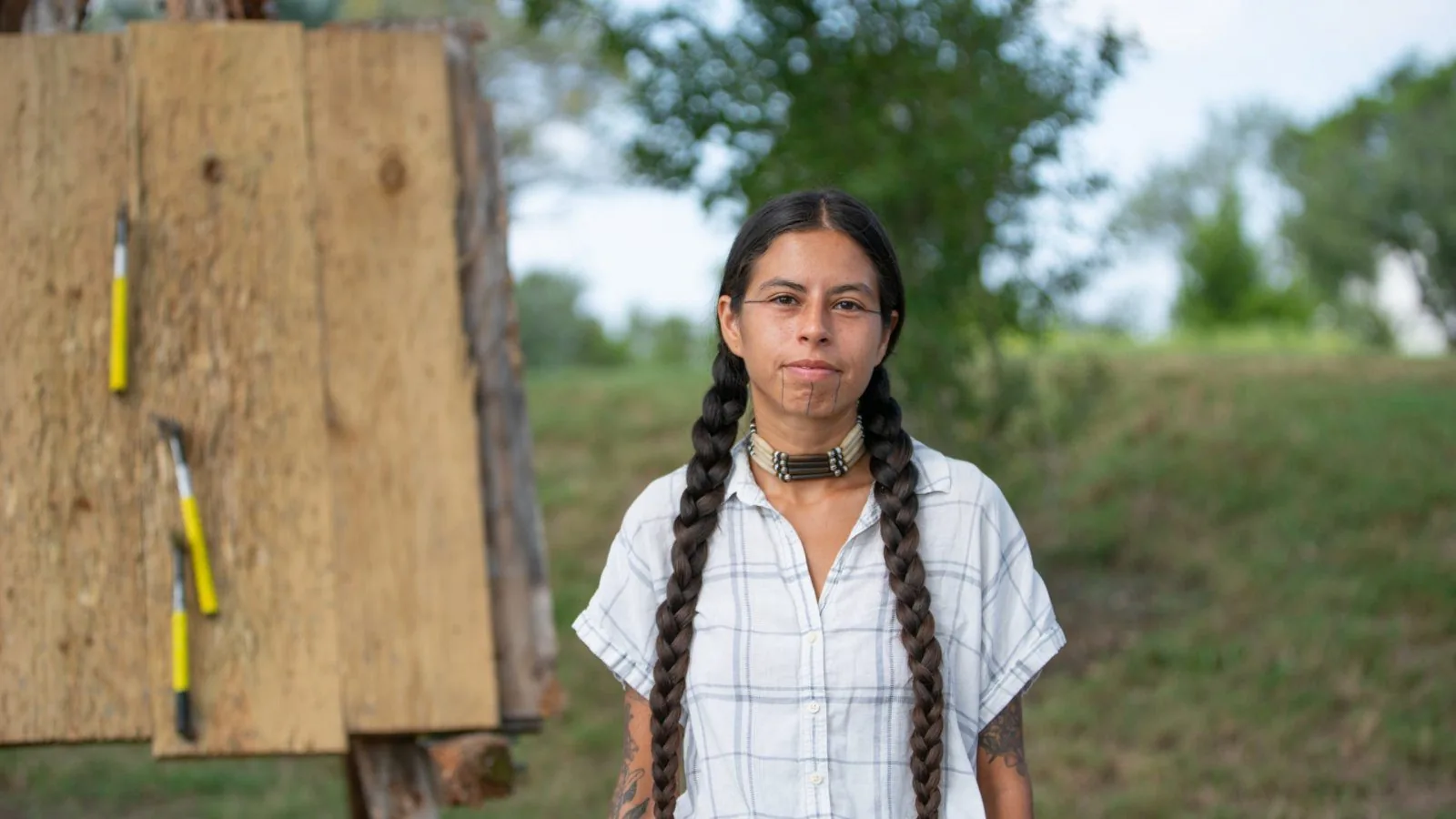 person wearing braids with native face tattoos