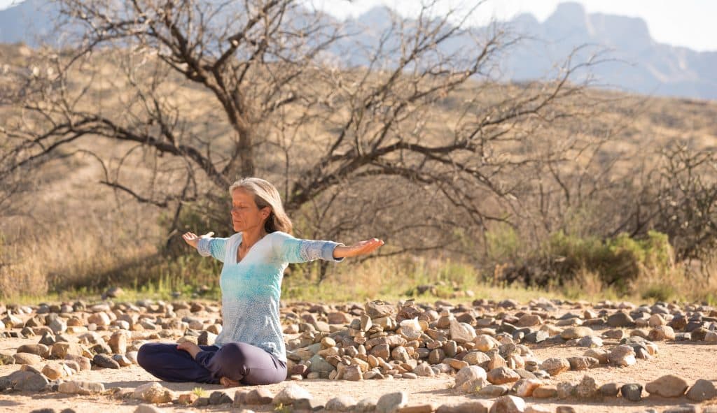 person sitting cross legged with arms out like a bird