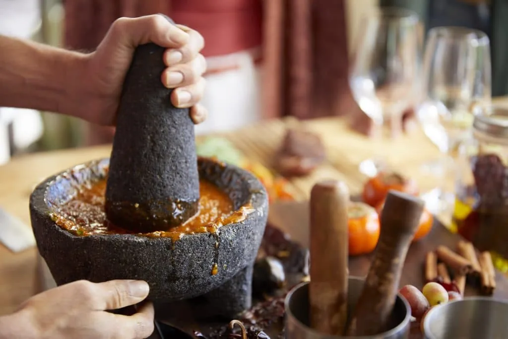 person grinding ingredients in a bowl