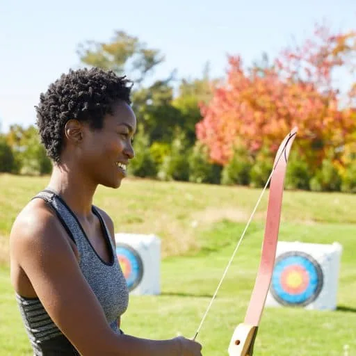 person holding a bow with a view of a target