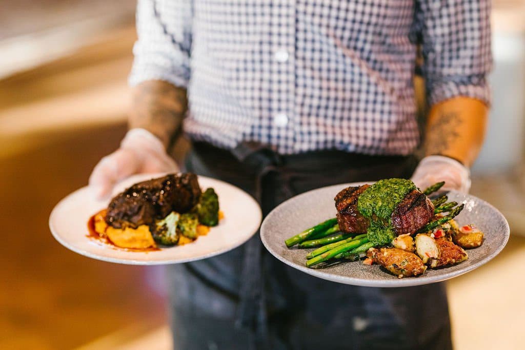 person carrying two plates of food