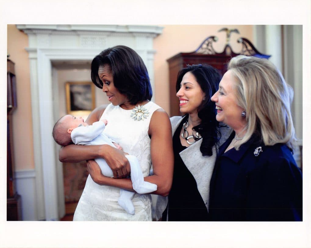 Michelle Obama holding baby, Huma Abedin, Hillary Clinton