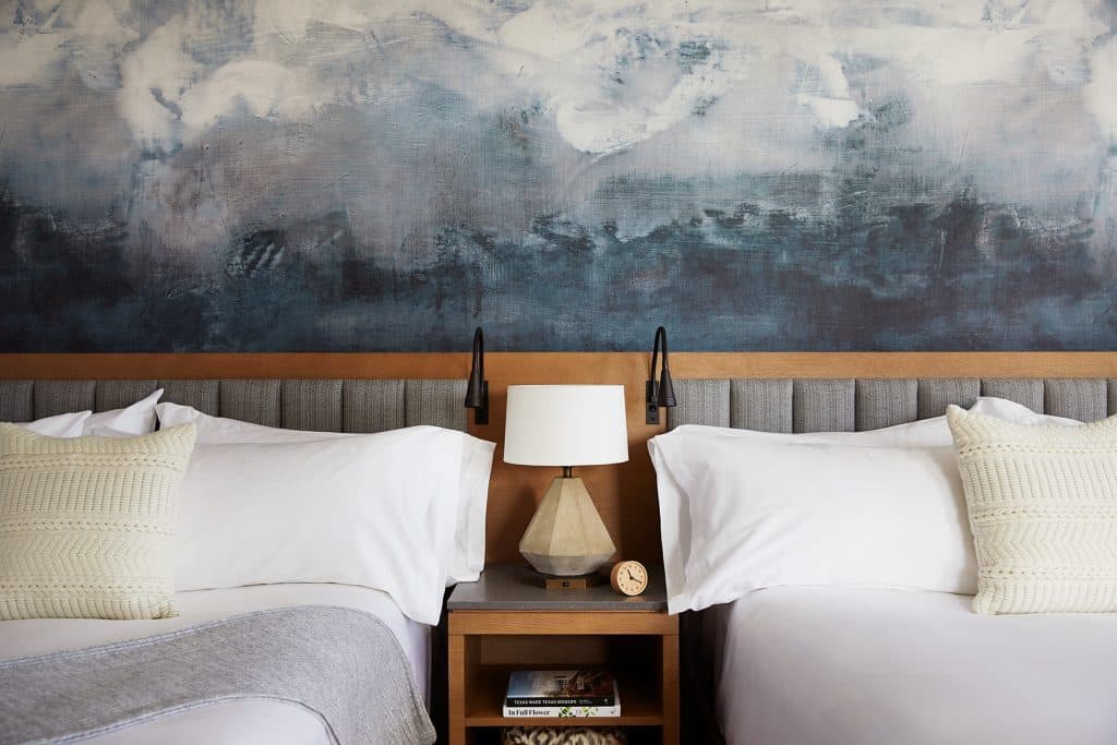 closeup of double beds and night table with lamp 