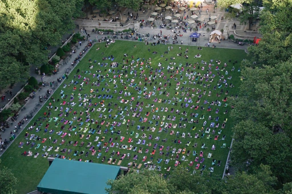 Aerial view of a lot of people doing yoga in the park