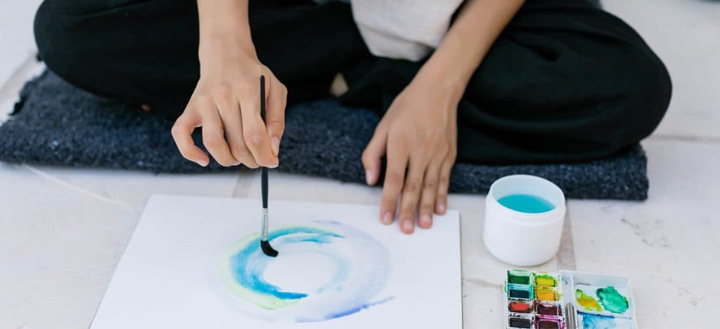 Closeup of person painting watercolour with paint brush