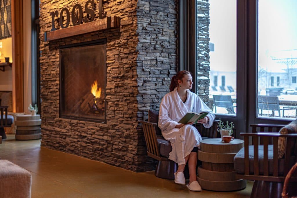 Woman in robe sitting on window reading a book