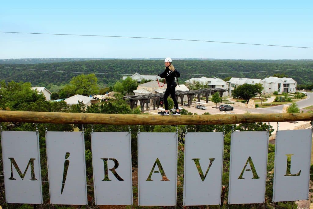 Content manager holding on rope at Leap of Faith on the Blue Heron Challenge Course