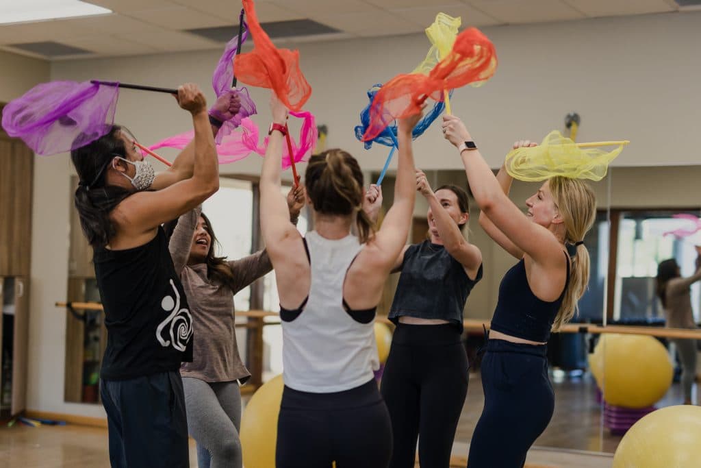 women in gym making movements with silk scarfs