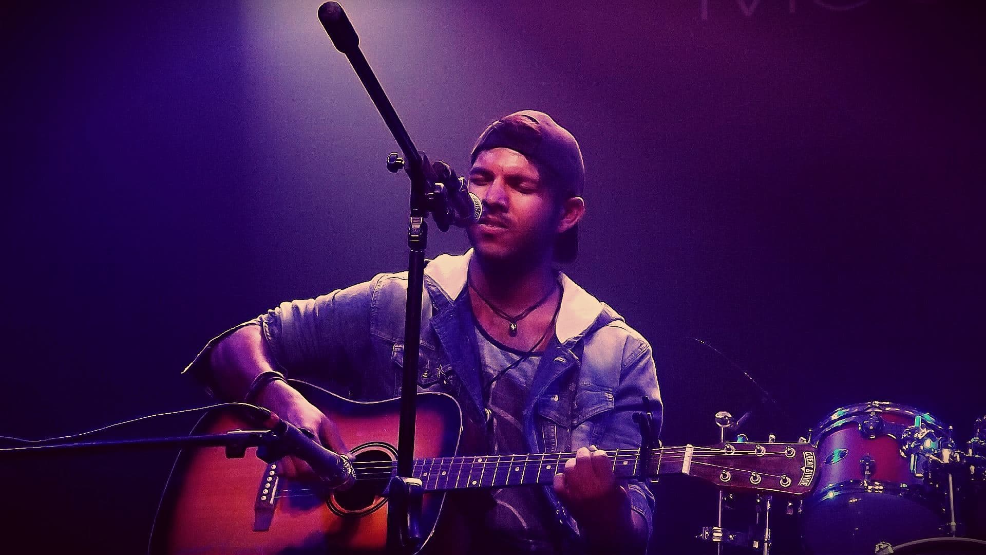 Matthew Coelho playing the guitar and singing