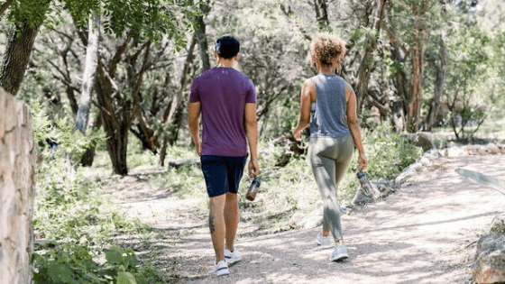 Two people walking on path in forrest